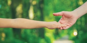 Child reading to hold parents hand