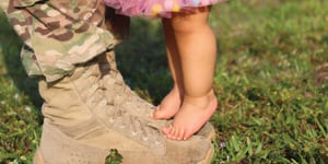 military boots with a little girl on his toes