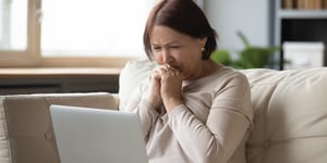 older person looking at laptop upset