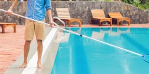 person cleaning pool summer