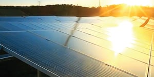 sun setting on solar panels