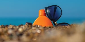 sunscreen and sunglasses on beach